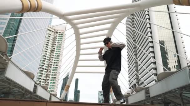 Junge asiatische Hipster zeigen ihre Schritte in der Innenstadt, umgeben von Menschen. Stylische Streetdancer führen B-Boy-Tänze oder Freestyle-Tänze mit niedrigem Winkel auf. Outdoor-Sport 2024. Breakdance. Schwungvoll. - Filmmaterial, Video