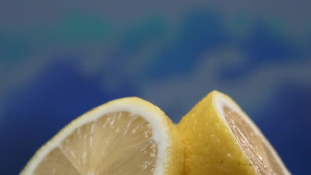 Een schijfje verse citroen, helder geel en levendig citroen, ligt bloot. Het vlees, glinsterend van verfrissend sap, onthult zijn gesegmenteerde binnenkant. De essentie van citrus levendigheid. Bestanddelen. - Video