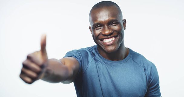 Thumbs up, exercise and portrait of black man on a white background for training, workout and fitness. Sports, emoji and happy person trainer for gym promotion, subscription and wellness in studio. - Photo, Image
