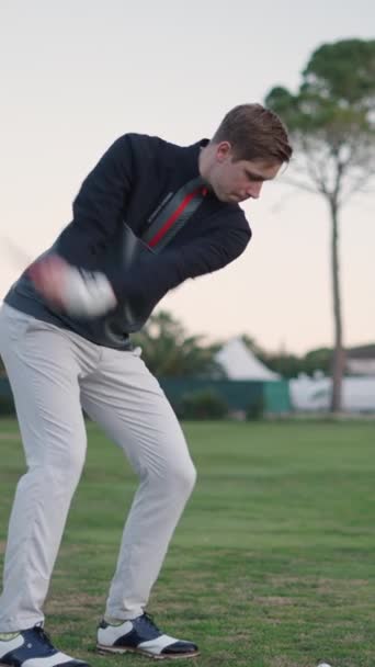 Een lange blonde jongen neemt een golf shot - FullHD Verticale video - Video