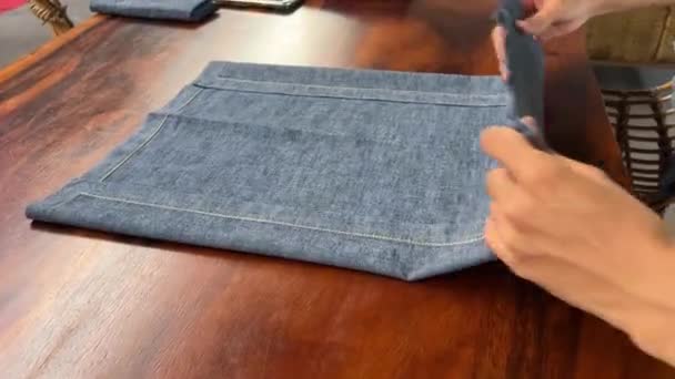 Folding new linen dinner napkin on a white wooden table. Fold gray cloth napkins - Footage, Video