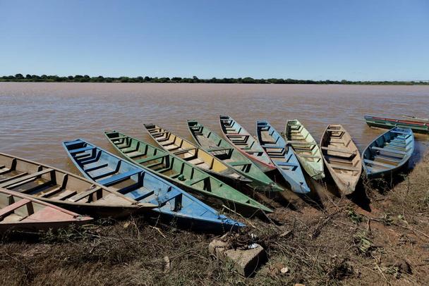 carinhanha, bahia, brasil - 13 de abril de 2024: Canoas de pescadores são vistas presas às margens do rio São Francisco, na cidade de Carinhanha. - Foto, Imagem