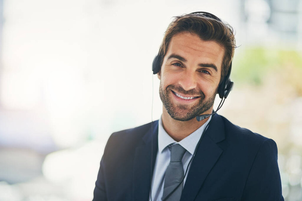 Šťastný muž, portrét a konzultant se sluchátky v call centru pro zákaznický servis nebo podporu v kanceláři. Přátelský podnikatel, zaměstnanec nebo agent s úsměvem pro on-line poradenství, pomoc nebo pomoc. - Fotografie, Obrázek
