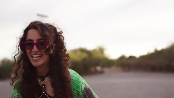 Счастливая молодая кавказская женщина в солнечных очках наслаждается празднованием прав ЛГБТ с другими поколениями z людей на открытом воздухе, прыгая и танцуя вместе. Празднование месяца гей-прайдов - Кадры, видео