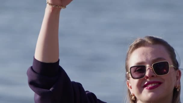 Молода блондинка робить знак серця з її рукою на пляжі - Кадри, відео