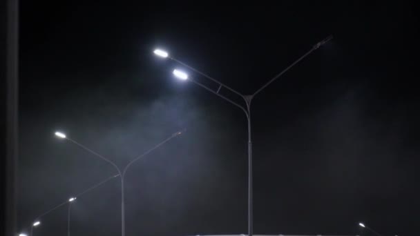 Ομιχλώδης νύχτα στο πάρκινγκ με φώτα του δρόμου. Νύχτα, επιλεκτική εστίαση - Πλάνα, βίντεο