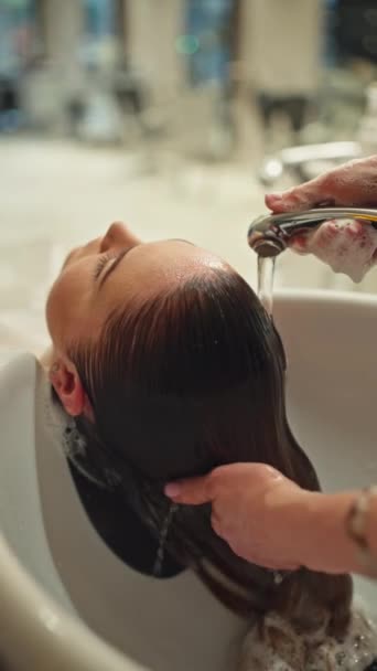 Elegante servizio di parrucchiere: lavaggio dei capelli e preparazione al taglio di capelli in un salone di fascia alta. Filmati 4k di alta qualità - Filmati, video