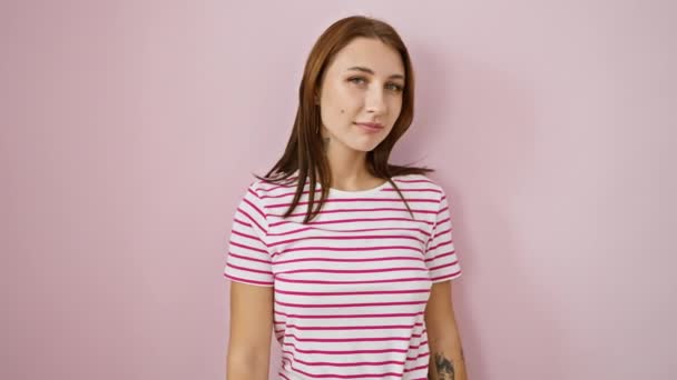 Rozzářená mladá brunetka v proužcích tričko šklebící se od ucha k uchu, přátelsky nabízející pevný stisk ruky jako přátelské obchodní gesto nad růžovým, izolovaným pozadím. - Záběry, video