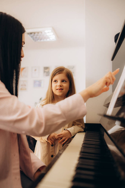 Petite fille apprenant à jouer du piano avec professeur
 - Photo, image