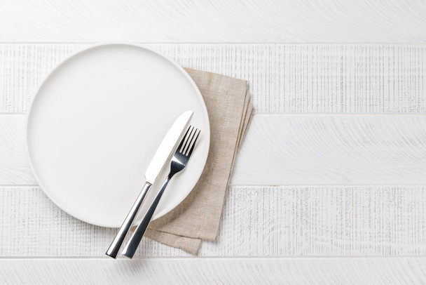 Assiette vide, fourchette et couteau sur table en bois, vue aérienne avec espace de copie - Photo, image