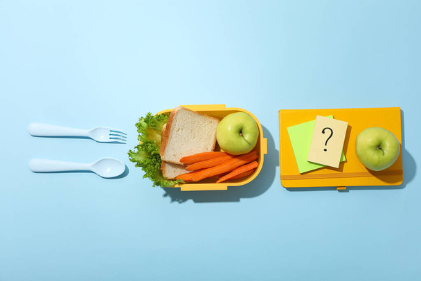 Gele lunchbox met brood, appel en wortel - Foto, afbeelding