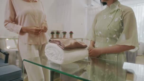 Gesneden schot van schoonheid salon manager geven handdoek aan vrouwelijke klant komen voor de procedure - Video
