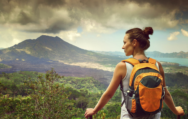 Jonge vrouw reiziger op zoek op Batur vulkaan. Indonesië - Foto, afbeelding