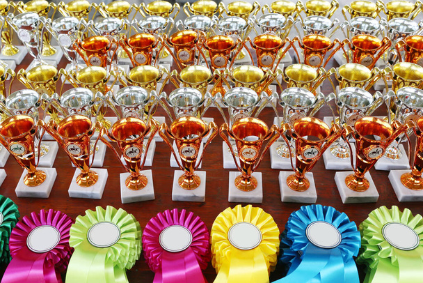 Gruppo di bellissimi trofei e nastri colorati per i vincitori e partecipanti all'evento ippico all'aria aperta       - Foto, immagini