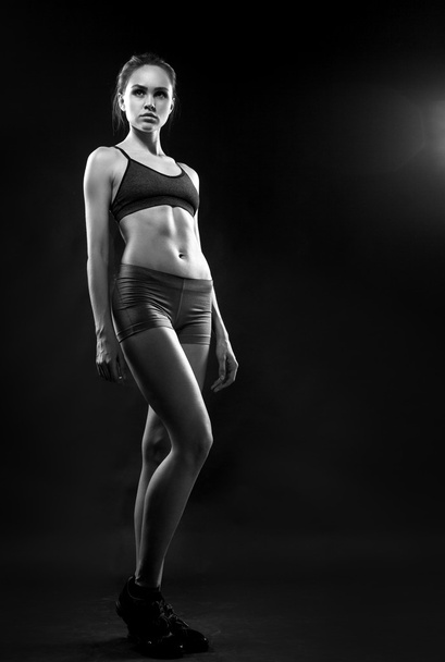 Портрет спортивної молодої жінки з м'язистим тілом дивиться на камеру
 - Фото, зображення