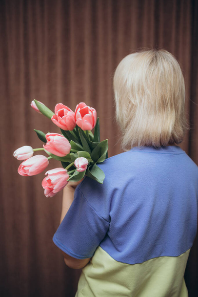 жінка тримає букет тюльпанів з синьою сорочкою на - Фото, зображення