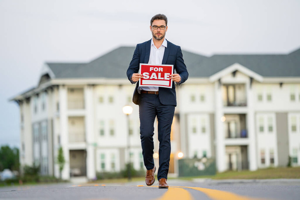 Businessman buying and selling houses and real estate. real state agent giving new house key. Estate agent with customer before contract signature. male real state agent with a for sale or rent sign. - Photo, Image