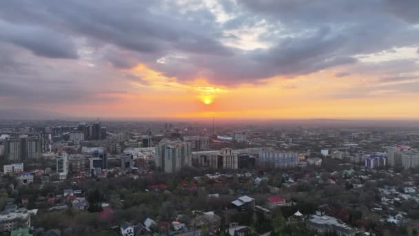 Uitzicht vanaf een quadcopter van de grootste stad Kazachstan, Almaty, op een voorjaarsavond bij zonsondergang - Video