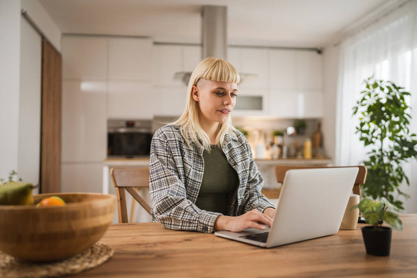 młody biały blondynka praca na laptop z domu szczęśliwy pozytywny - Zdjęcie, obraz