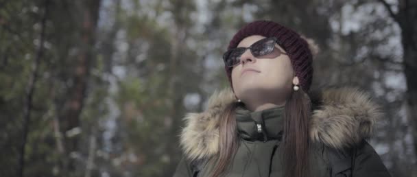 Frau spaziert an einem sonnigen Wintertag durch den Kiefernwald. Zeitlupe.  - Filmmaterial, Video