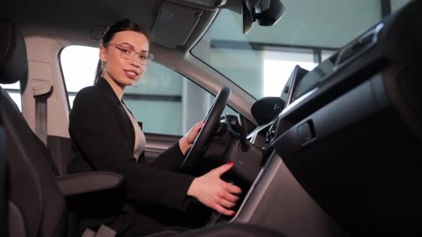 Una donna si trova sul sedile del conducente di un veicolo, mostrando il design automobilistico e le caratteristiche esterne. Lei è visto fare un gesto all'interno del veicolo a motore - Filmati, video