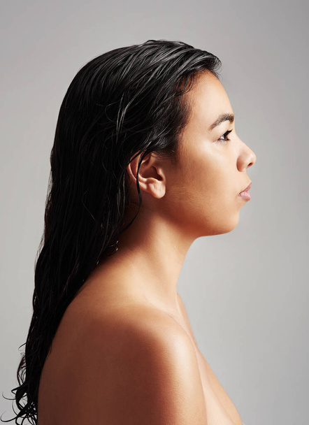 Woman, profile and beauty with haircare, salon or cosmetics on a gray studio background. Young female person or model with wet hair or shower in spa wash, hygiene or keratin and facial treatment. - 写真・画像