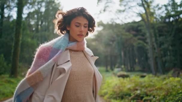 Beautiful traveler walking autumn park in scarf embodying elegance at nature daylight. Gorgeous woman strolling wood path expressing grace and poise closeup. Fashionable girl enjoy tranquil journey. - Footage, Video