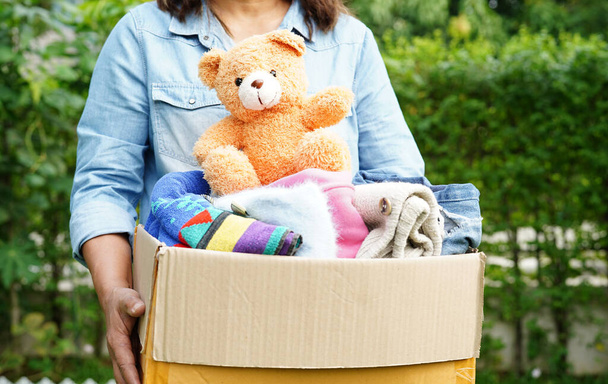 Recueillir bénévolement tissu et poupée dans une boîte en carton pour faire un don. - Photo, image