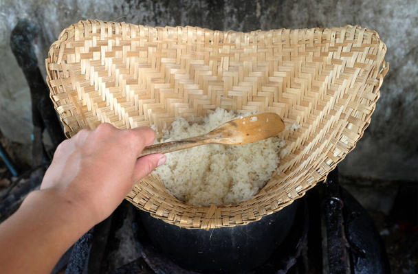 zbliżenie w górę kobieta Azji Scoop gorący lepki ryż w stary drewniany parowiec, pachnący, bardzo przystawek gotować ryż, lepki ryż, gorący lepki ryż w stary drewniany parowiec. - Zdjęcie, obraz