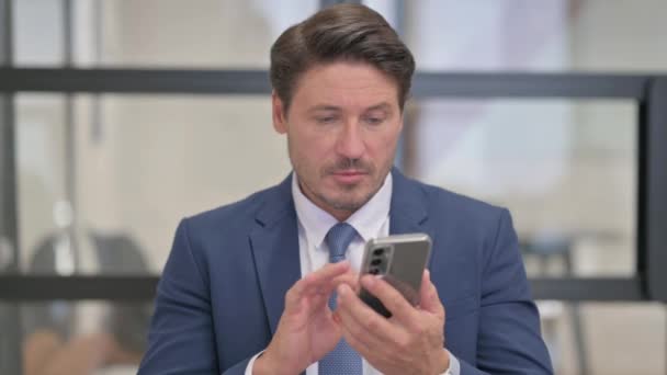 Portrait of Middle Aged Businessman Celebrating Success on Phone - Footage, Video