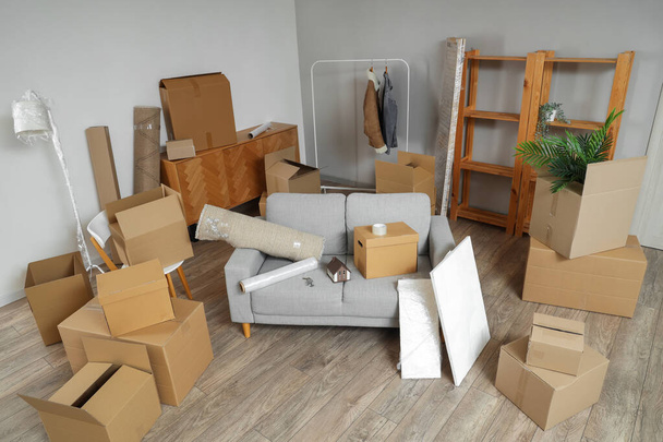Καναπές με κουτιά από χαρτόνι στο σαλόνι την ημέρα που κινείται - Φωτογραφία, εικόνα