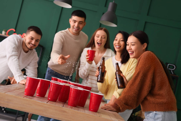 Gruppo di giovani amici che giocano a beer pong alla festa - Foto, immagini