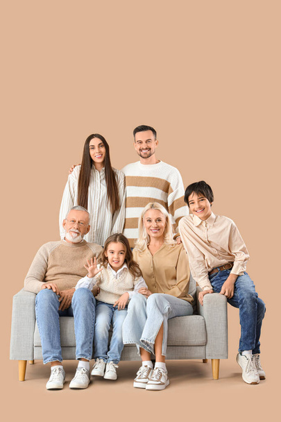 Grande famille assise sur canapé sur fond beige - Photo, image