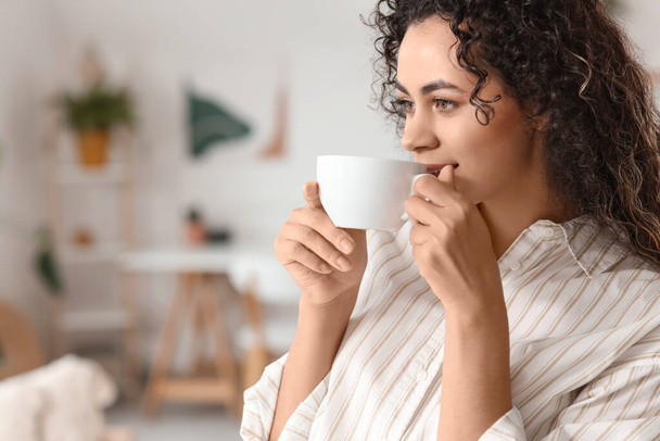 自宅でコーヒーを飲む若いアフリカ系アメリカ人女性,クローズアップ - 写真・画像