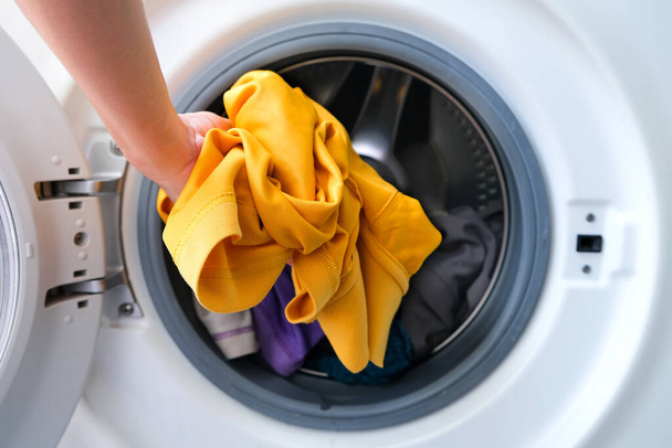 Die Hand der Frau Pick-up Kleidung Waschmaschine.Saubere und gesunde Konzepte - Foto, Bild