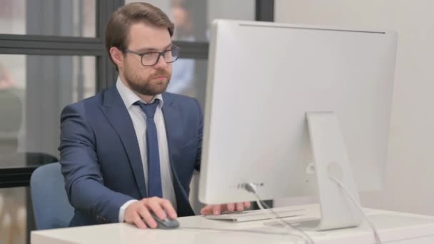 jeune homme d'affaires travaillant sur ordinateur au bureau - Séquence, vidéo