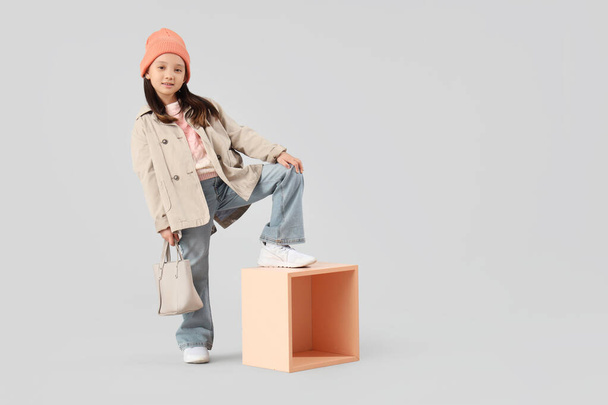 Porträt von modischen kleinen Mädchen mit Handtasche posiert auf weißem Hintergrund - Foto, Bild