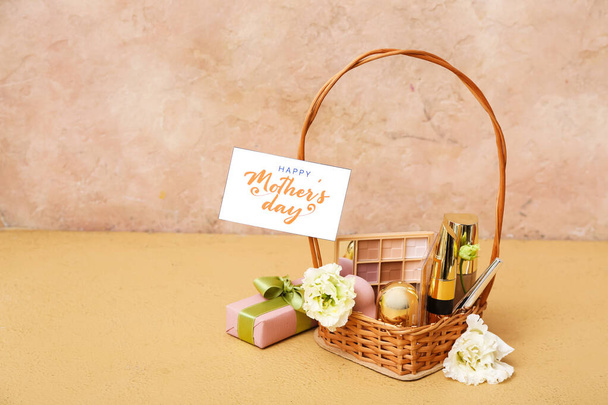 Korb mit Kosmetikprodukten, Geschenkbox und Karte für Muttertagsfeier auf farbigem Hintergrund - Foto, Bild