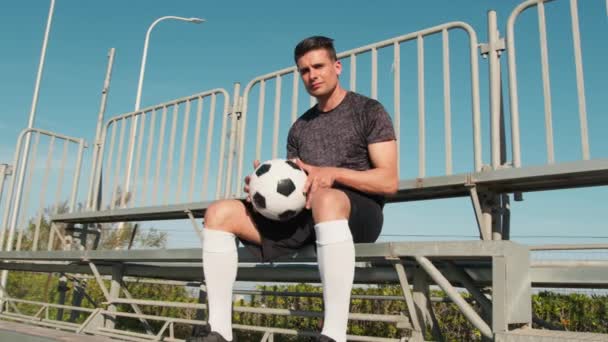 Sousedství chlapec sedí v Stojí s fotbalovým míčem v ruce - Záběry, video