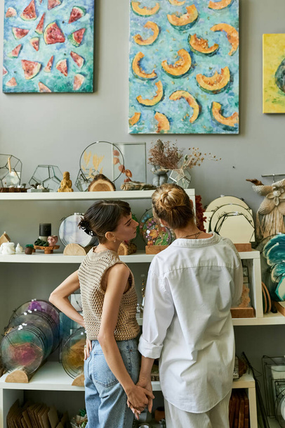 Két nő egy művészeti stúdióban, egy gyengéd pillanaton osztoznak.. - Fotó, kép