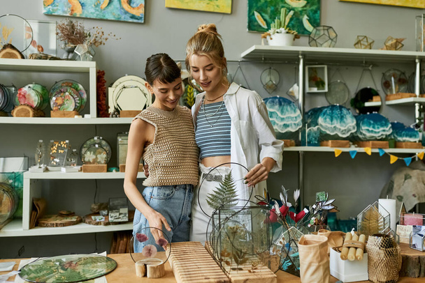 Twee artistieke vrouwen die samen voor een houten tafel staan. - Foto, afbeelding