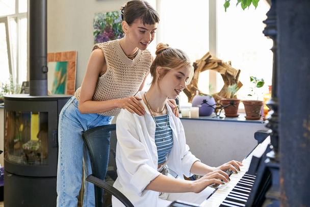 Kız arkadaşıyla birlikte sanat stüdyosunda piyano çalan bir kadın.. - Fotoğraf, Görsel