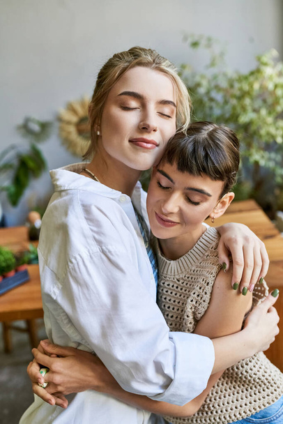 Duas mulheres compartilhando um abraço sincero em um estúdio de arte. - Foto, Imagem
