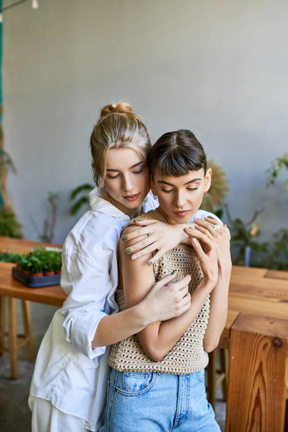 Dos mujeres abrazándose tiernamente en un estudio artístico. - Foto, imagen