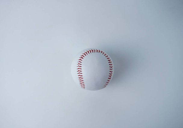 Wit en rood gekleurde honkbal sport bal object fotografie geïsoleerd op horizontale witte studio achtergrond van bovenhoek. - Foto, afbeelding
