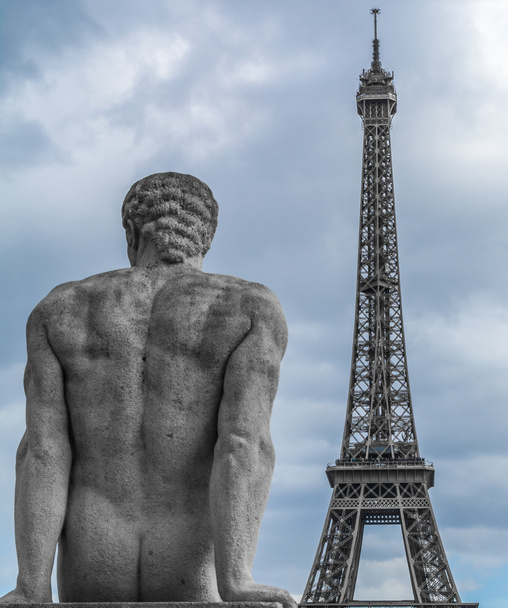 Estatua de piedra sobre la torre Eiffel en el fondo
 - Foto, Imagen