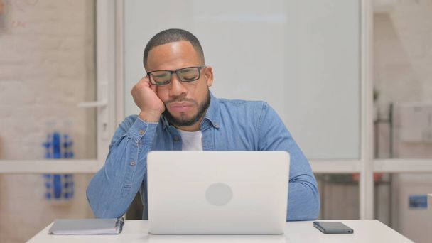 Mann mit gemischter Rasse schläft während er am Laptop arbeitet - Foto, Bild