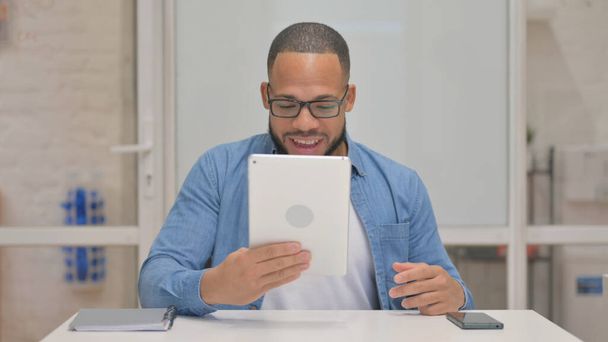 Mann mit gemischter Rasse führt Videochat auf Tablet - Foto, Bild