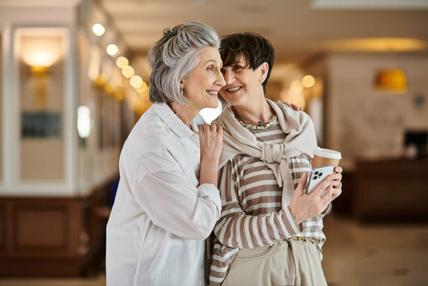 Un tenero momento tra due partner lesbiche anziane in un hotel. - Foto, immagini