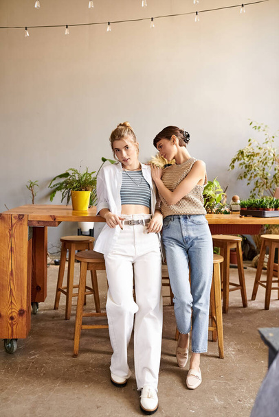 Un couple lesbien tendre et aimant se tient dans un studio d'art, entouré de créativité. - Photo, image
